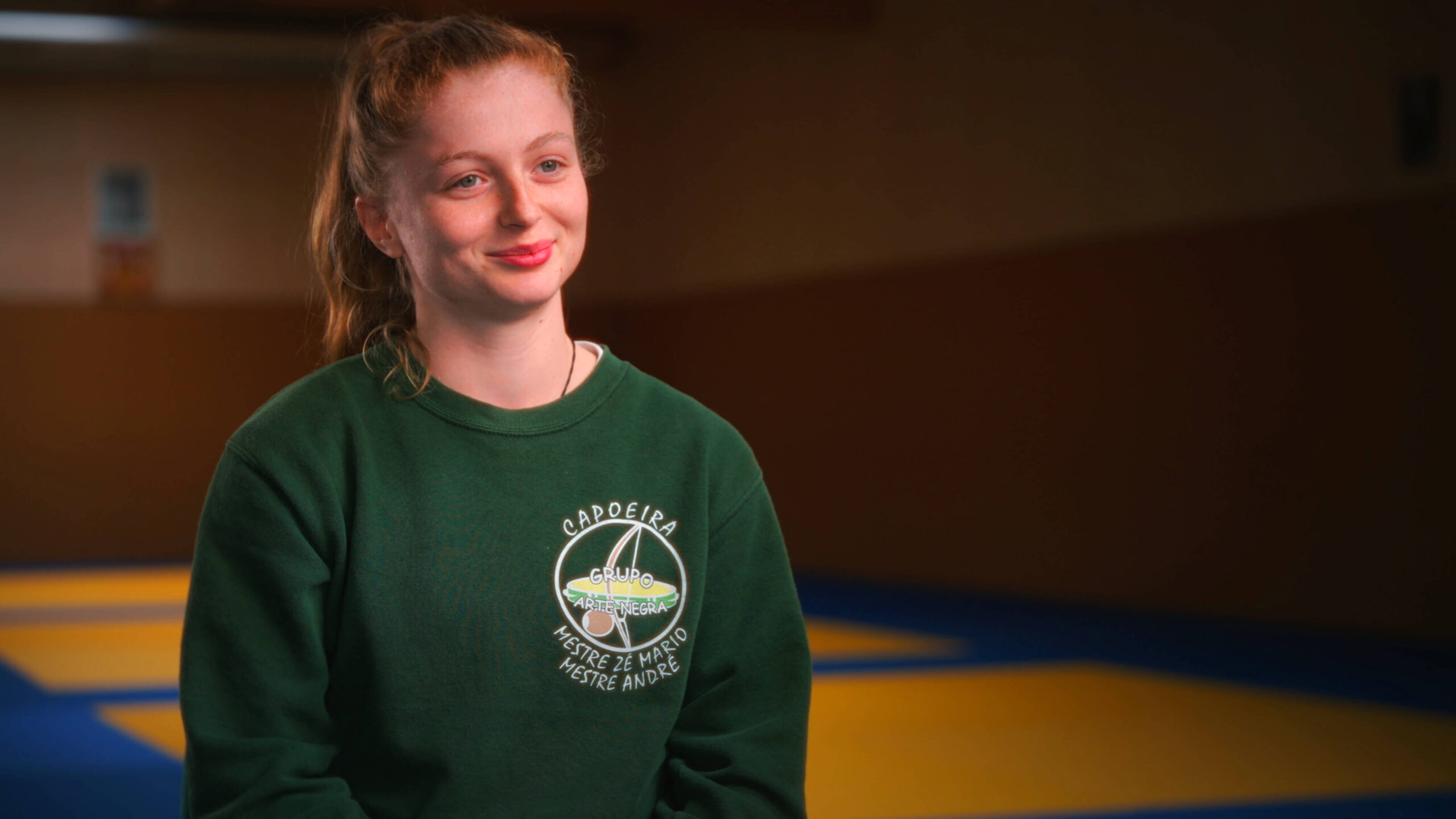 Mahrie Corbu interviewée dans une salle d’entraînement de capoeira