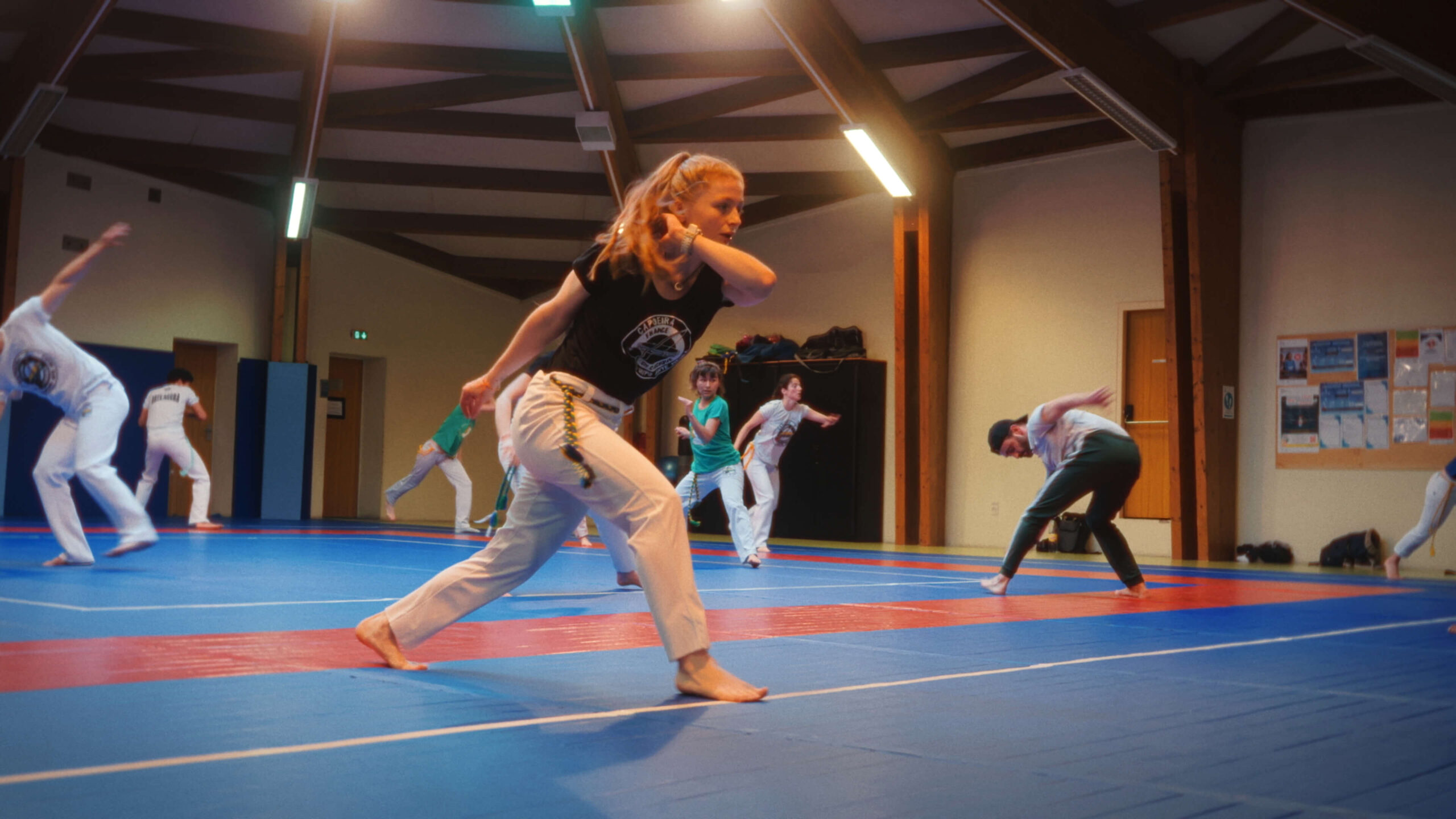 Mahrie Corbu s’entraînant à la capoeira avec son groupe dans un gymnase