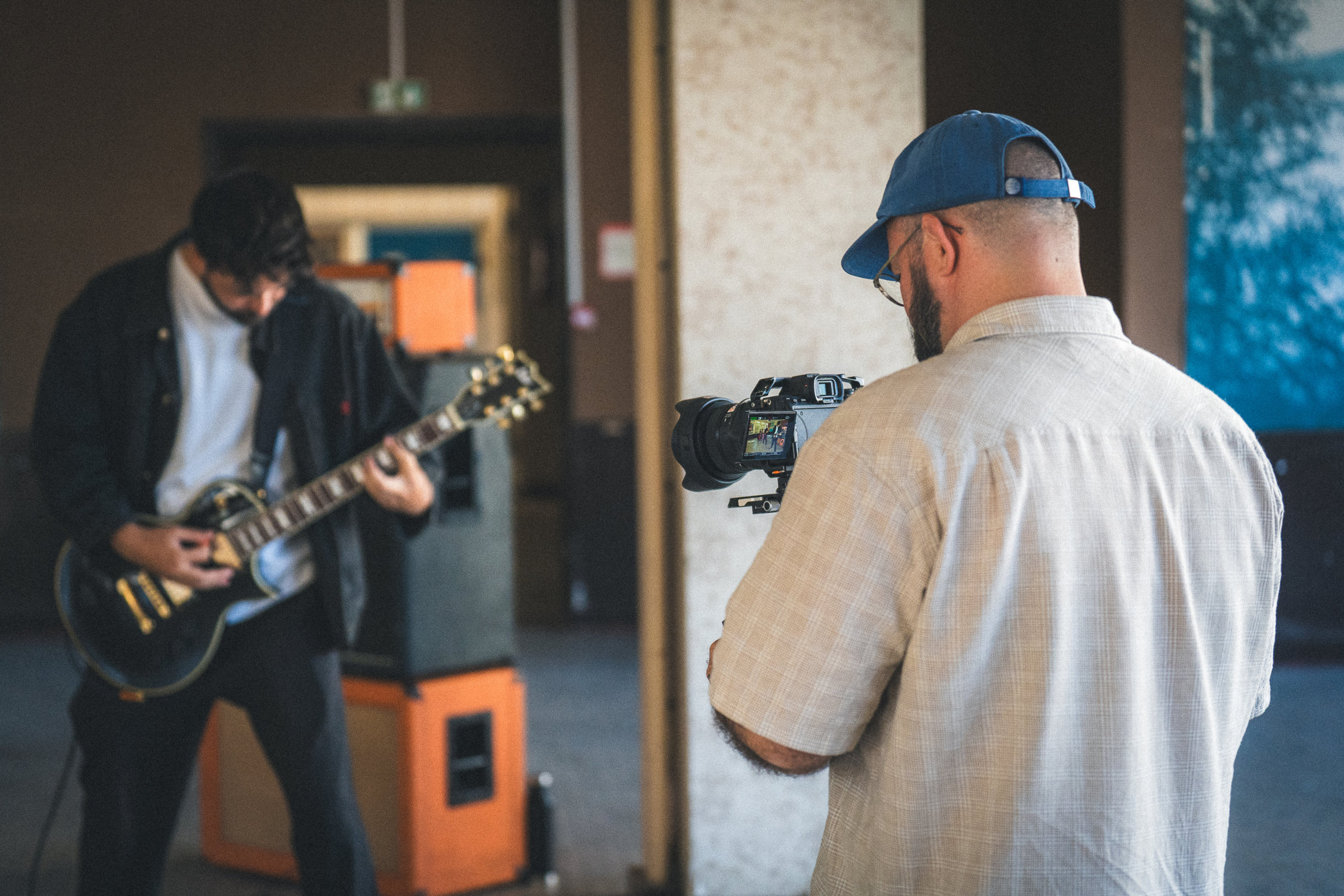 Réalisateur filmant un guitariste pendant le tournage d’un clip musical